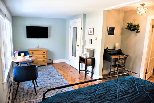 a bedroom with a bed and a desk and a table at Inn on Golden Pond in Holderness