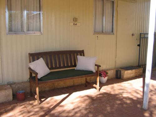 a bench with two white pillows sitting on a patio at THE MEYERS HOUSE - ACCOMMODATION in Kalgoorlie