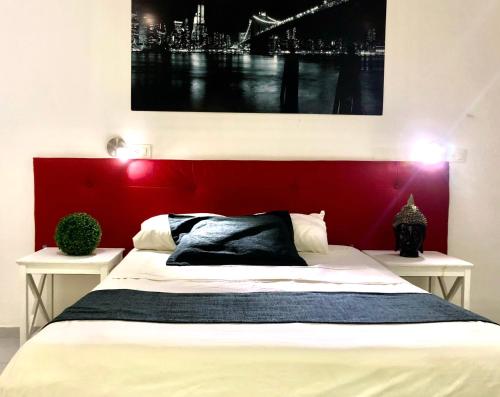 a bed with a red headboard in a room at Zyan Rooms in Villahermosa