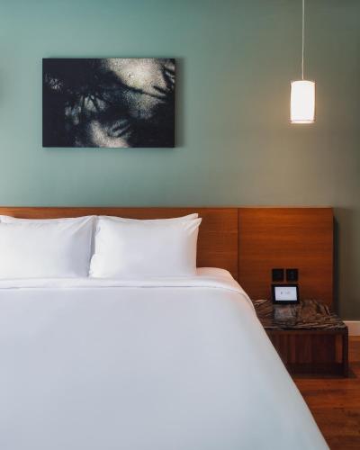 a bedroom with a large white bed and a table at RELO' The Urban Escape - Huahin in Cha Am