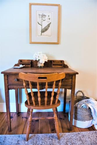 a wooden desk with a chair in a room at Inn on Golden Pond in Holderness