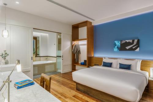 a bedroom with a large bed and a bathroom at RELO' The Urban Escape - Huahin in Cha Am