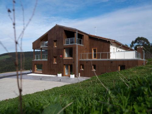 uma grande casa de madeira no topo de uma colina em Hotel Nafarrola - Gastronomy & Wine em Bermeo