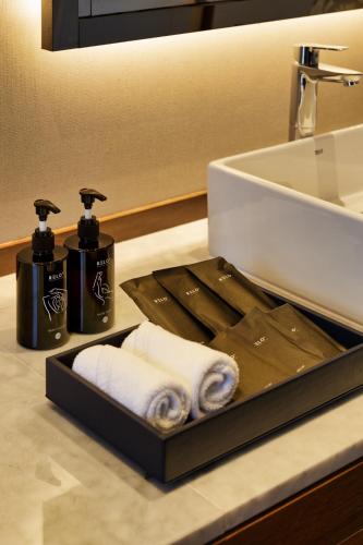 a bathroom counter with a tray with towels and a sink at RELO' The Urban Escape - Huahin in Cha Am