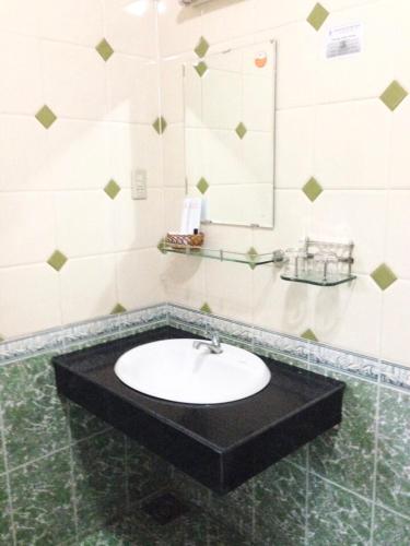 a bathroom with a sink and a mirror at Huyen Tran Hotel in Can Tho