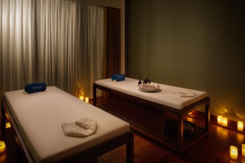 a room with two beds and a table with food on it at RELO' The Urban Escape - Huahin in Cha Am
