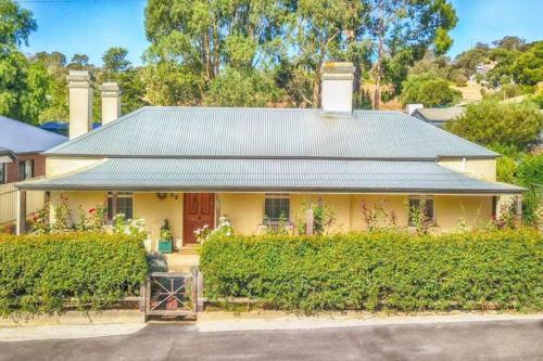 a yellow house with a green roof at Barossa Valley’s Captain Rodda’s Cottage in Angaston