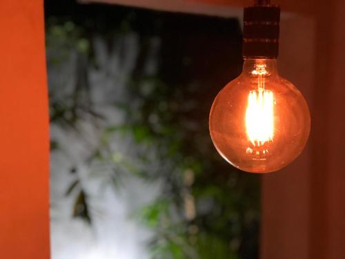 a glass light bulb hanging from a ceiling at Zyan Rooms in Villahermosa