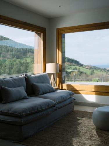 a living room with a couch and a large window at Hotel Nafarrola - Gastronomy & Wine in Bermeo
