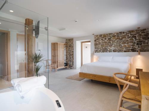 a bedroom with a bed and a stone wall at Hotel Nafarrola - Gastronomy & Wine in Bermeo