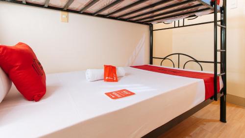 a bedroom with a bunk bed with red pillows at RedDoorz Plus at Alpina Heights Paranaque in Manila