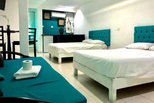 a bedroom with two beds and a table and chairs at Zyan Rooms in Villahermosa