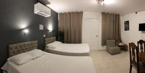 a hotel room with two beds and a chair at Zyan Rooms in Villahermosa