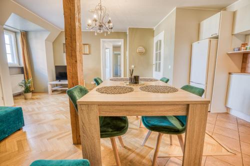 a dining room with a table and green chairs at Historic Residence Apartments at Old Town in Tallinn