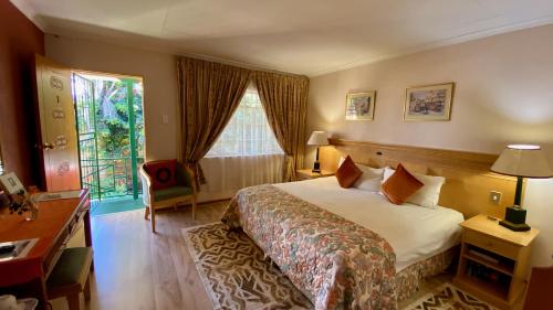 a hotel room with a bed and a window at Shamrock Arms Guest Lodge in Waterval Boven