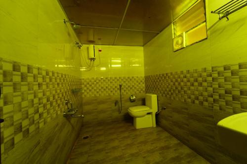 a bathroom with a toilet and a sink at Malgudi Farms in Bangalore