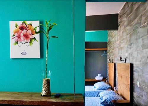 a room with two beds and a vase with a flower at Zyan Rooms in Villahermosa
