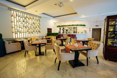a restaurant with tables and chairs and a bar at Hotel Metropolis in Surgut