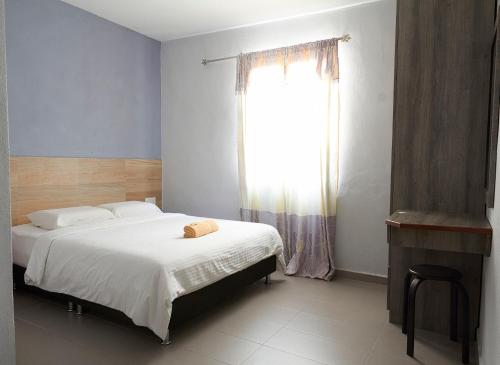 a bedroom with a large bed and a window at Corrie Chalet Pantai Cenang Langkawi in Pantai Cenang