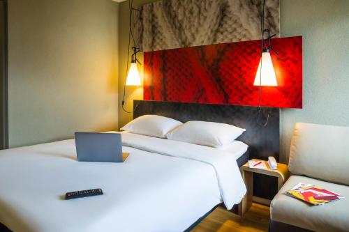 a hotel room with two beds with a laptop on it at ibis Rueil-Malmaison Centre in Rueil-Malmaison
