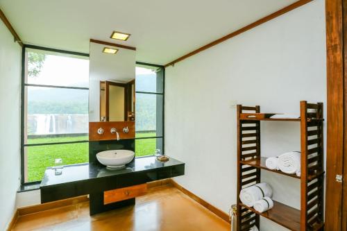 a bathroom with a sink and a mirror at Rainforest Resort in Athirappilly