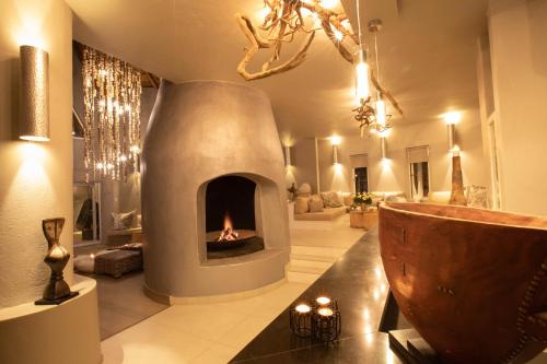 a living room with a fireplace in the middle at Clifftop Exclusive Safari Hideaway in Welgevonden Game Reserve