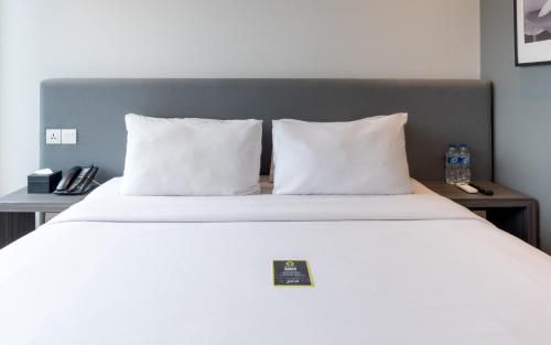 a bed with two white pillows and two night stands at Juno Tanah Abang Jakarta in Jakarta