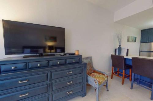 a living room with a blue dresser with a large television at Little Harbor Resort #510 Tampa Bay FL Beach, Hot Tub, Pools in Ruskin