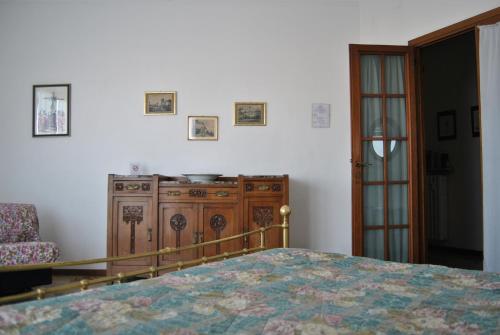 a bedroom with a bed and a wooden dresser at Lombardi Fleming in Parma