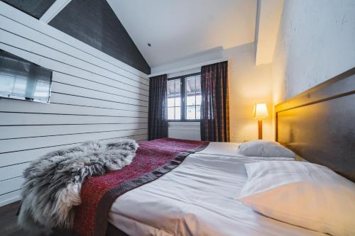 Un dormitorio con una cama con una manta. en Vietti Suites en Tahkovuori