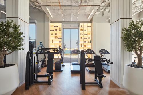 a gym with cardio equipment in a building at Vida Beach Resort Umm Al Quwain in Umm Al Quwain