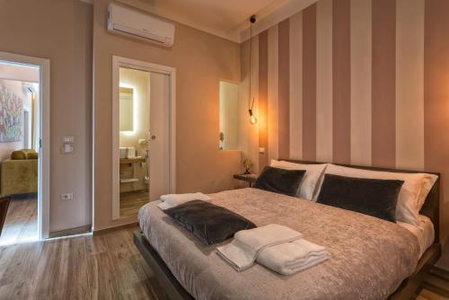 ein Schlafzimmer mit einem großen Bett mit Handtüchern darauf in der Unterkunft GOGO` Petit Hotel in Florenz