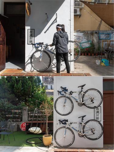 a man is holding a bike on a wall at 框框背包客棧 Kuang Kuang Hostel in Longjing