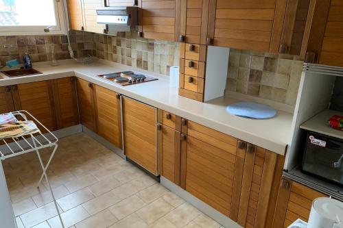 une cuisine avec des armoires en bois et un comptoir blanc dans l'établissement VISTABELLA by K6 Conciergerie, à Cassis