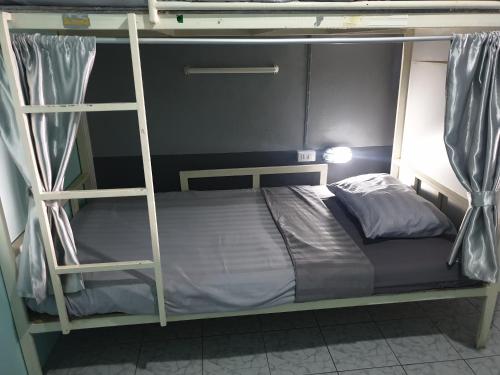 a bunk bed with a ladder in a room at i-smile in Chiang Mai