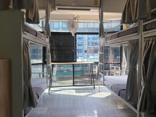 a room with two beds and a table in it at i-smile in Chiang Mai