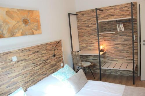 a bedroom with a brick wall next to a bed at Am Blumenhaus in Bamberg