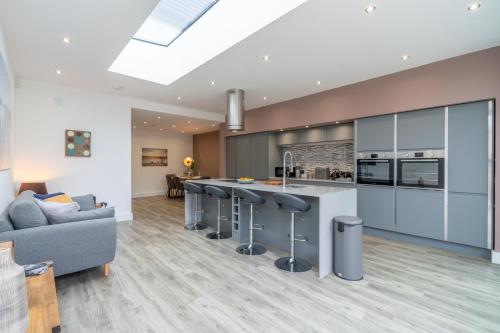 an open kitchen and living room with a gray couch at 33 Percy Street in Stratford-upon-Avon
