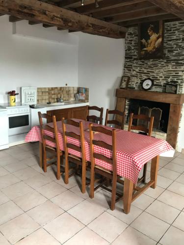 a kitchen with a table with a red and white table cloth at Ferme de la roque in Millières