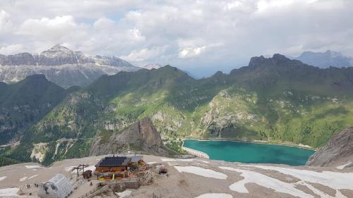a view of a mountain with a blue lake at Hotel Soreghes Gran Chalet in Campitello di Fassa