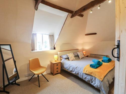 a bedroom with a bed and a chair at Kings Cottage in Grantham