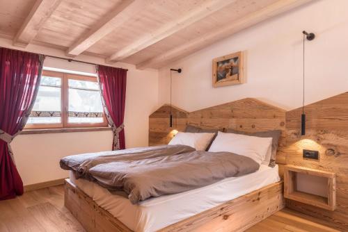 1 dormitorio con 1 cama grande en una habitación en Majon Baticher, en Canazei