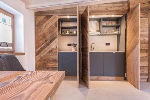 a kitchen with wooden walls and a wooden table at Majon Baticher in Canazei