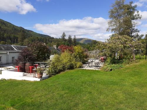 a yard with a lawn with a table and chairs at The White Stag Inn in Strathyre