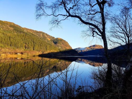 a view of a lake with trees and mountains at The White Stag Inn in Strathyre