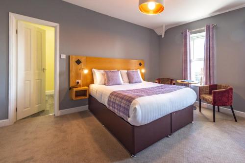 a bedroom with a bed and a table and a window at HK Rooms - Self Catering Rooms in Lowestoft