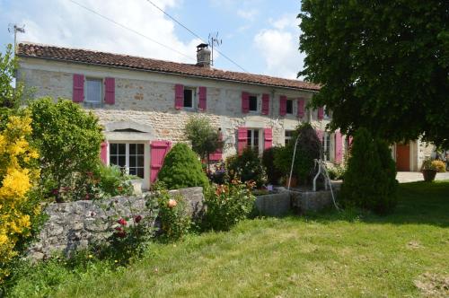 an old stone house with pink shutters and a yard at LA PASTORALE in Beurlay