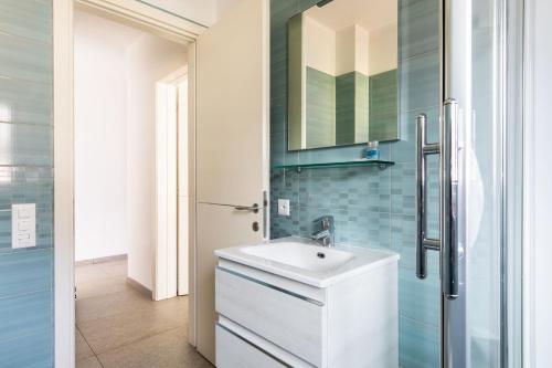 a bathroom with a white sink and a refrigerator at Roggia Apartments by Quokka 360 - central flats with parking space in Lugano