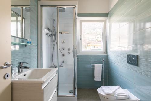 a bathroom with a shower and a sink and a toilet at Roggia Apartments by Quokka 360 - central flats with parking space in Lugano