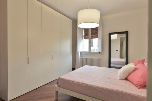 une chambre avec un lit avec des oreillers roses dans l'établissement UR-NEST Moline, à Bologne